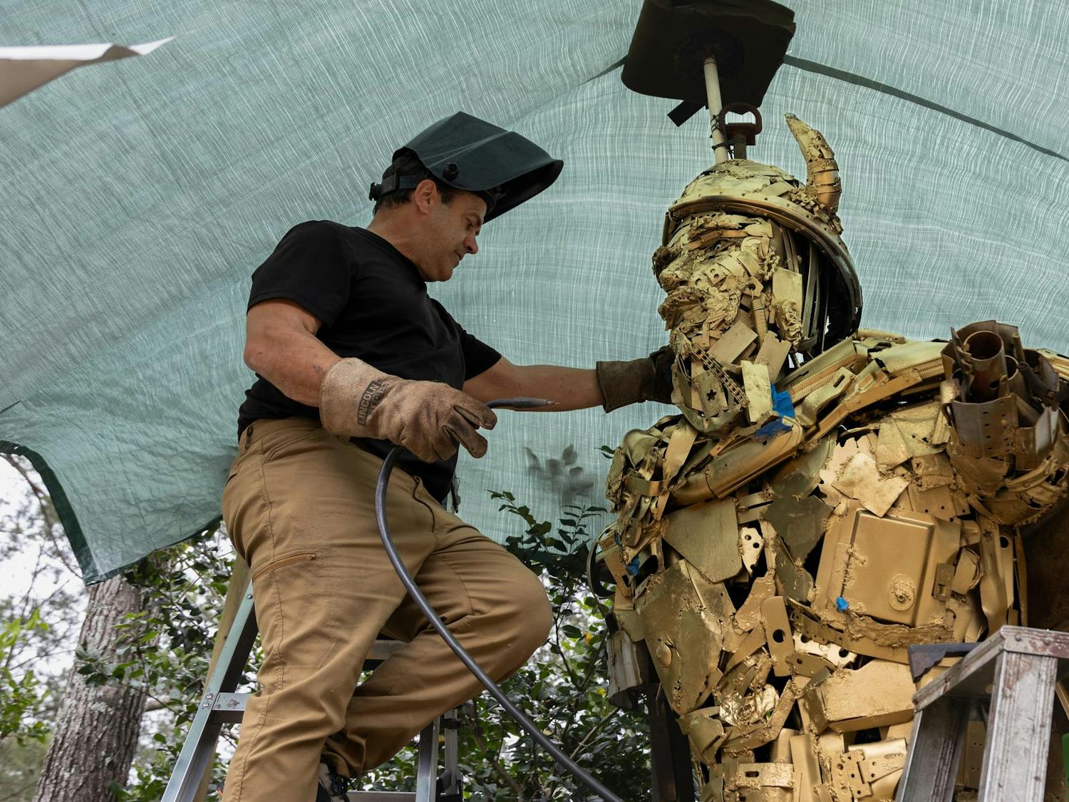 Humphries explains his process of building structures as he stands next to his largest creation yet, a 12-foot-tall Viking for Spring Valley High School. Humphries always begins his construction at the bottom and works his way up, but for the Viking, he started by creating a foam version of the structure to better visualize the size that he needed to build.