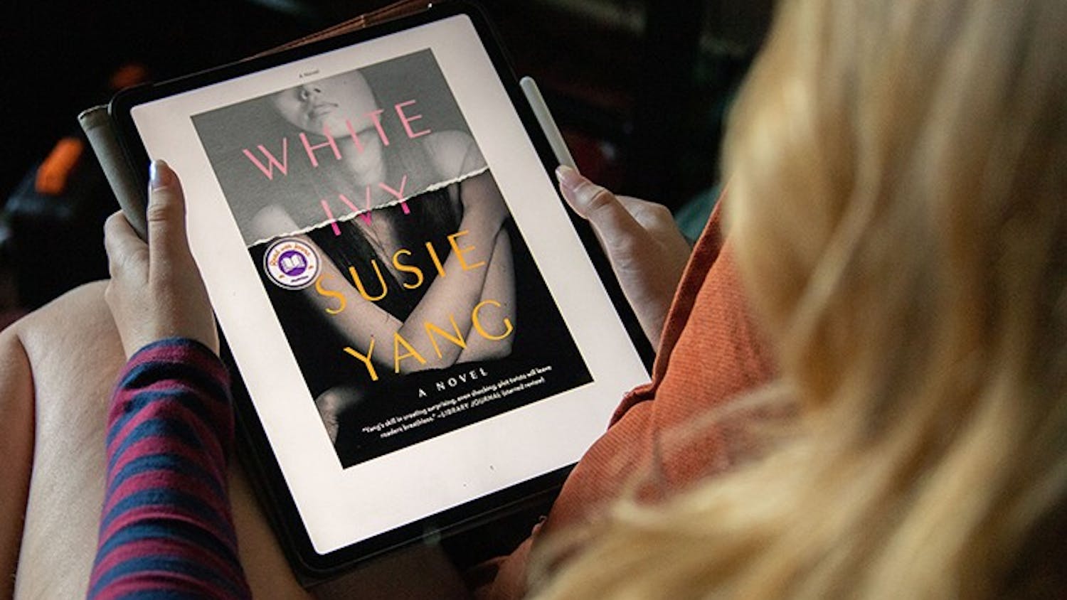&nbsp;&nbsp;A woman sits down on a chair to read the e-book version of Susie Yang's novel "White Ivy.”&nbsp;