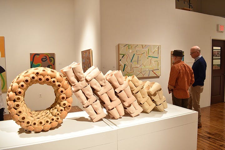 Jay Johnstone and Randy Schwartz observe an acrylic painting at "The Shape of Things" exhibition in the 701 Center of Contemporary Art in February 2020.&nbsp;