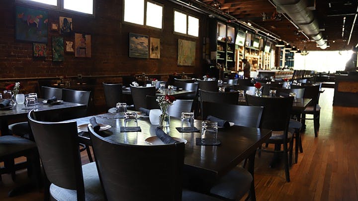 The inside of Hendrix , which is located above The Woody, includes many nicely set tables and a large bar.