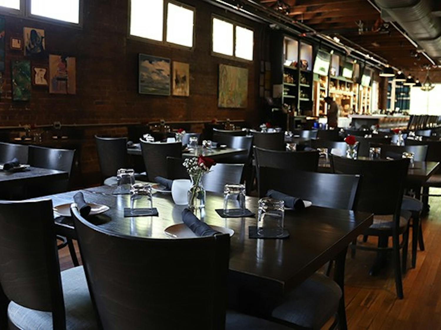 The inside of Hendrix , which is located above The Woody, includes many nicely set tables and a large bar.