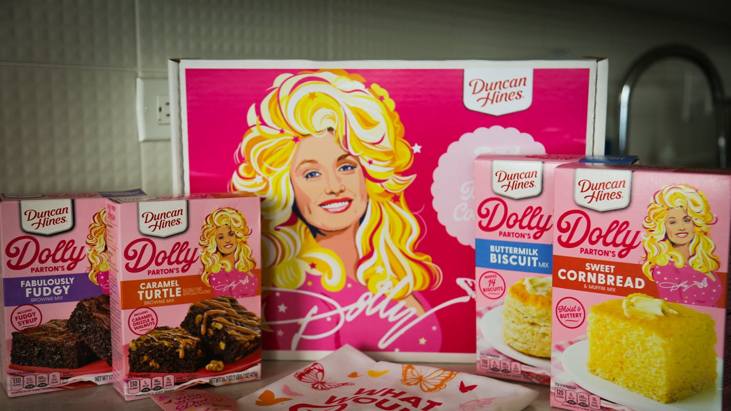 A photo illustration of Duncan Hines' Dolly Parton Baking Collection on Feb. 22, 2023. The kit was released early this month and includes two types of brownie mixes, a cornbread mix, a biscuit mix, a matching towel and spatula and collectible recipe cards.