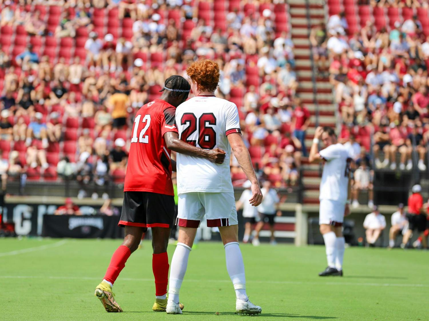 Senior forward Adam Luckhurst walks with a Gardner-Webb player during a water break on Aug. 27, 2023. The late August game was moved up due to the threat of rain and played in over 90-degree temperatures.
