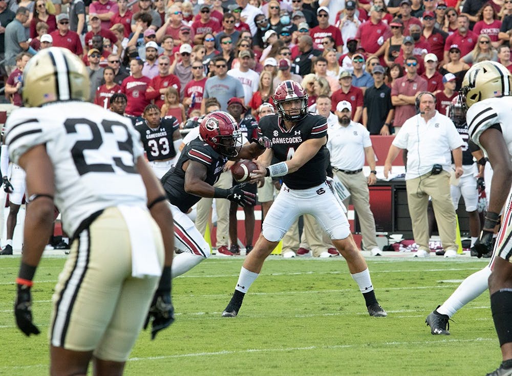 <p>FILE—Junior quarterback Luke Doty hands the ball off to redshirt sophomore running back MarShawn Lloyd for a gain of a couple yards against Vanderbilt on Oct. 16, 2021. The Gamecocks won 21-20.&nbsp;</p>