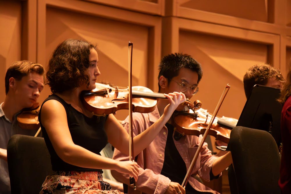 <p>Second-year music performance major Margie Moore reads her sheet music while sitting in the violin section of The Firebird and Phoenix at the Koger Center on Sept. 23, 2024.</p>