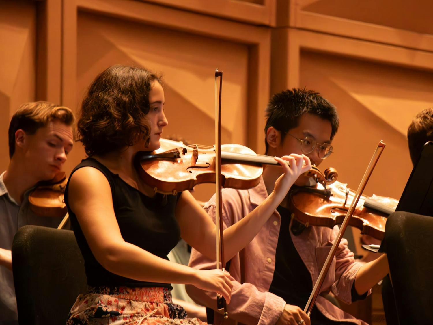 Second-year music performance major Margie Moore reads her sheet music while sitting in the violin section of The Firebird and Phoenix at the Koger Center on Sept. 23, 2024.
