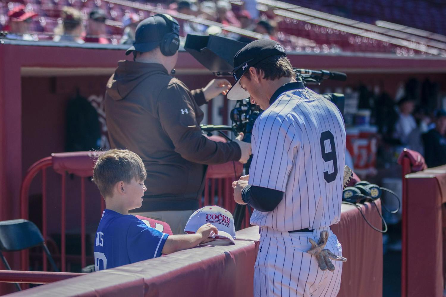 Junior outfielder Evan Stone autographs a young fan’s hat before South Carolina's game against Texas A&amp;M on April 6, 2024. Stone joined the ɫɫƵs as a freshman in 2022.