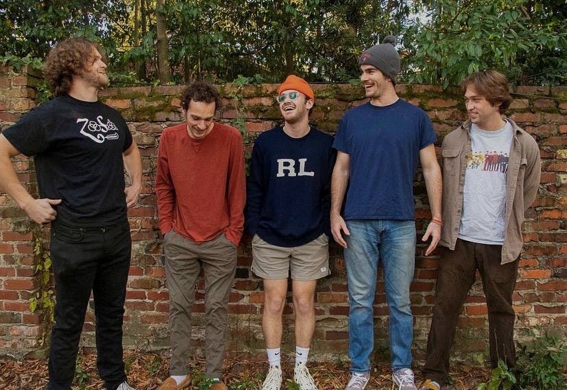 Rock band, Bull Street Garage, stands along a brick wall. Bull Street Garage performs in bars and clubs in the Columbia area.