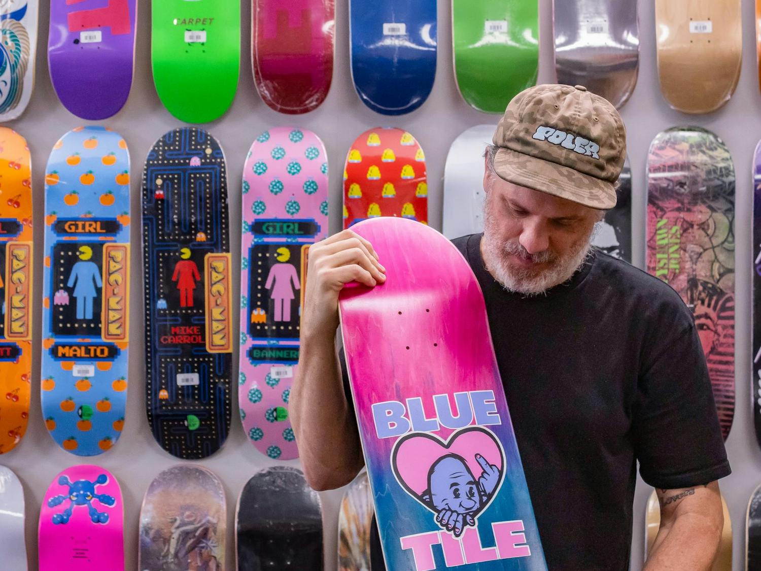 David Toole, the founder of Bluetile Skateboards, admires one of the many skateboards found on his infamous Wall of Skateboards on Oct. 4, 2024. The “Blue Tile” skateboard deck is one of his own, giving his household name a chance to reign on the streets of Columbia, South Carolina.