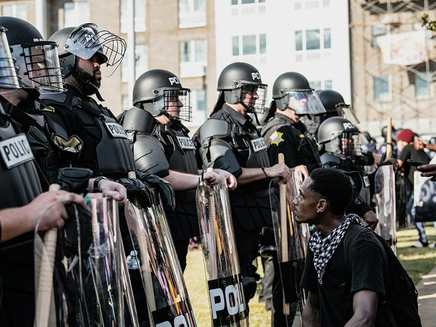A photograph by Crush Rush, one of the five photo journalists featured at the Hindsight 2020 exhibit, which features pictures of events that defined 2020. This popular image captures a protestor kneeling and looking up at a Black police officer at a police brutality protest at the Statehouse following the death of George Floyd.