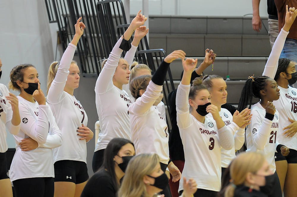 Members of the Women’s Volleyball team hold up their pinkies to signify one more point needed to win the set against Alabama. 