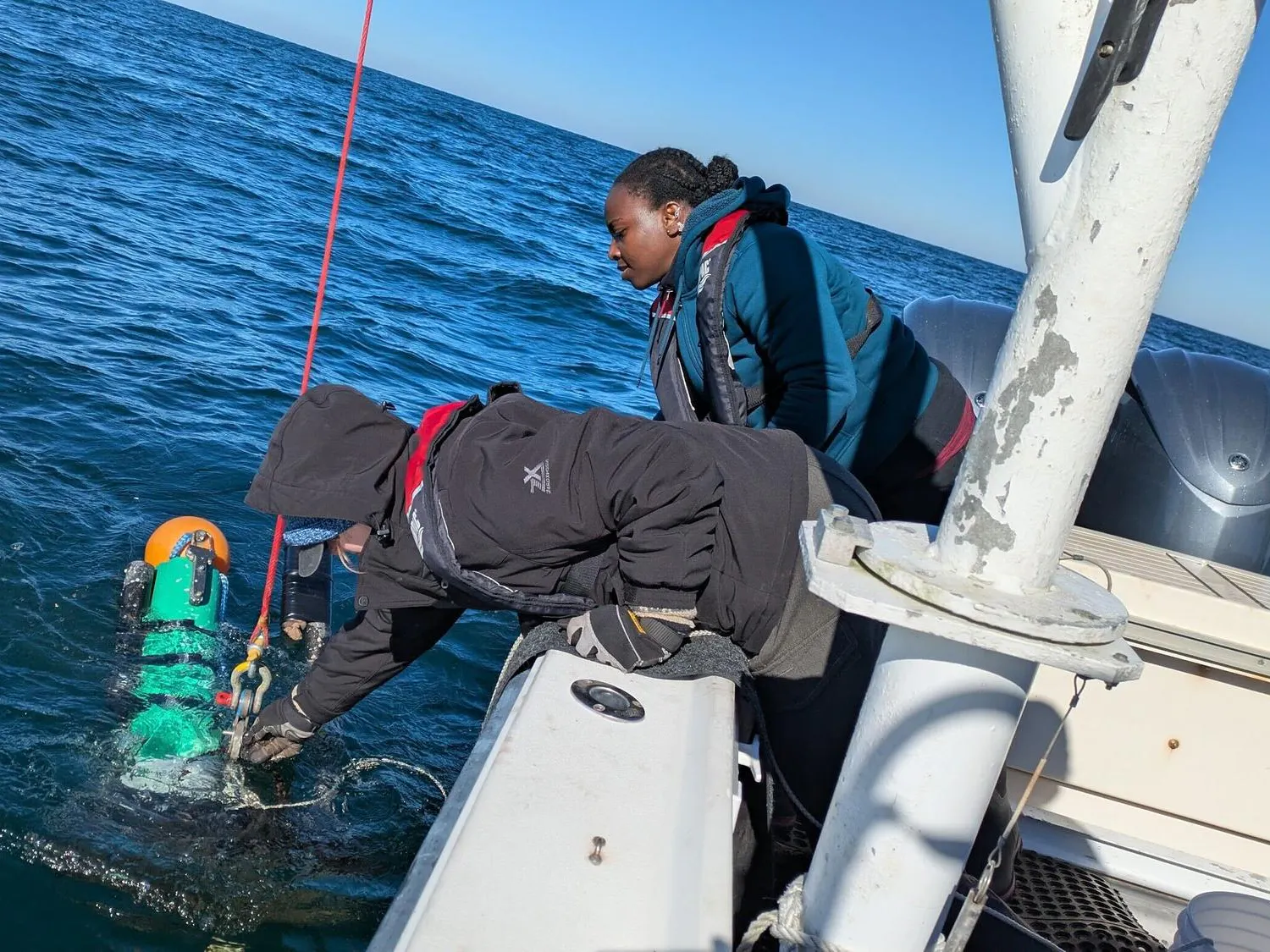 Lydia Sims and Amadi Afua Sefah-Twerefour are deploying one of the three moorings with their hydrophone to listen for North Atlantic right whales during the calving season in Savannah, Georgia.