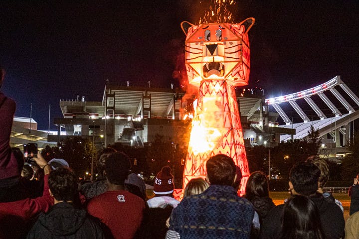 Students watch as the giant wood and steel-beam Clemson Tiger bursts into flames during the USC Tiger Burning Ceremony on Nov. 21, 2022. USC hosts this event annually during the week leading up to the South Carolina-Clemson football rival match the following Saturday. This year Clemson is hosting the game at their field, "Death Valley" on Nov. 26, 2022.