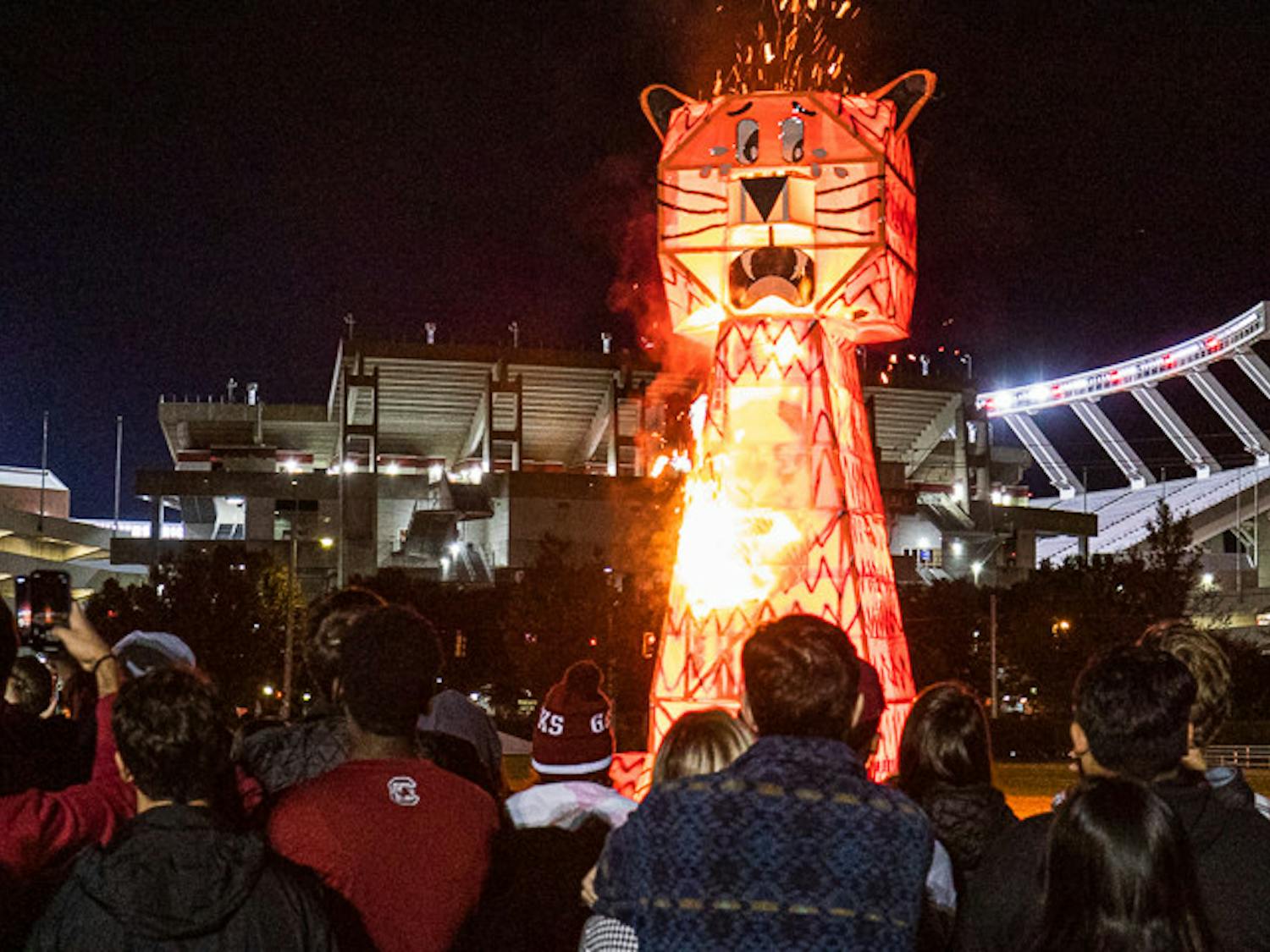 Students watch as the giant wood and steel-beam Clemson Tiger bursts into flames during the USC Tiger Burning Ceremony on Nov. 21, 2022. USC hosts this event annually during the week leading up to the South Carolina-Clemson football rival match the following Saturday. This year Clemson is hosting the game at their field, "Death Valley" on Nov. 26, 2022.