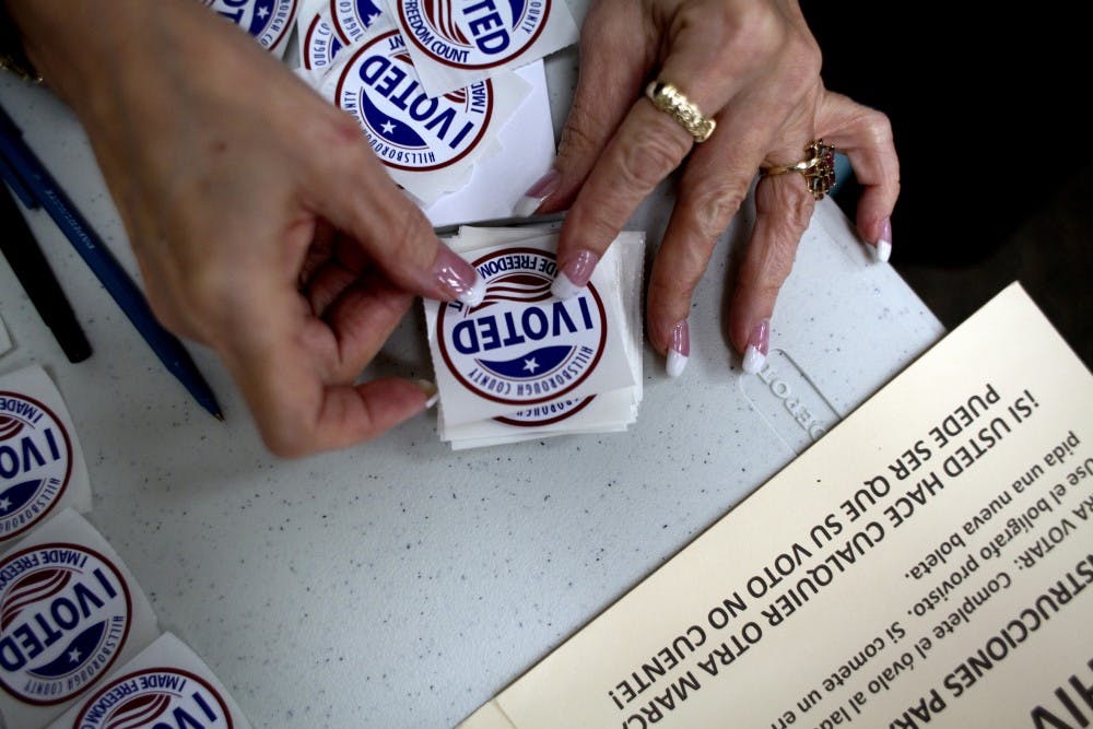 A poll worker gets "I Voted" stickers ready to hand to voters as they finished up at the ballot booths at Jan Kaminis Platt Regional Library in South Tampa, Fla., on November 6, 2012. (Carolina Hidalgo/Tampa Bay Times/TNS)
