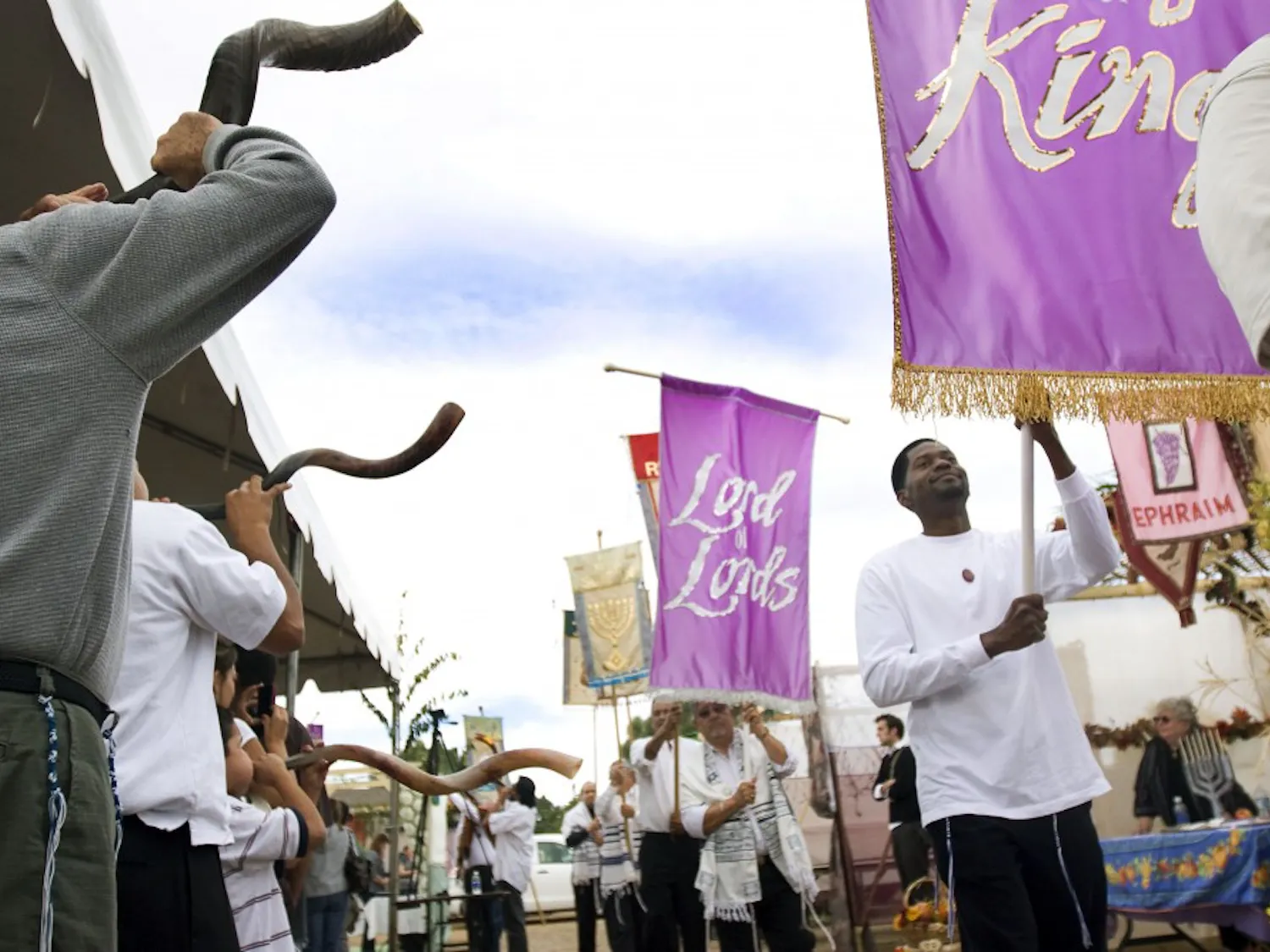 Banner carriers walk in front of the Olive Tree Messianic Temple Saturday to celebrate Sukkot, a Jewish feast day. This is the fifth annual celebration at Olive Tree of the Feast of Tabernacles, which commemorates the Jewish pilgrimage to Jerusalem.