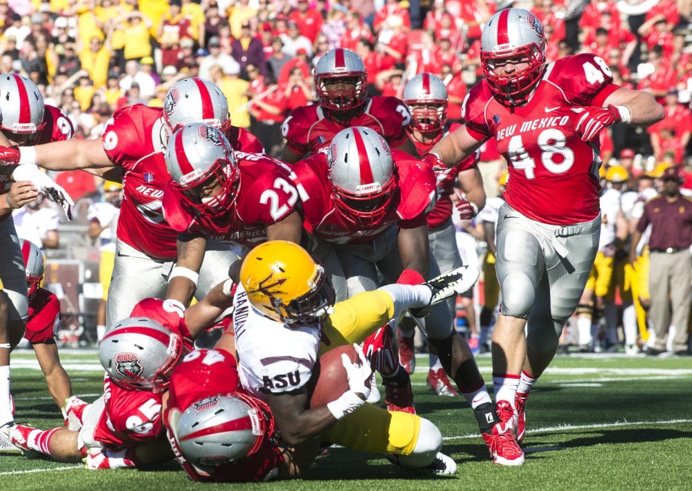 A swarm of New Mexico players tackle an Arizona State player during the Sept. 6 New Mexico vs. Arizona State game. The Lobos will meet in-state rivals New Mexico State Aggies for the 105th Rio Grande Rivalry at Aggie Memorial Stadium in Las Cruces this Saturday.