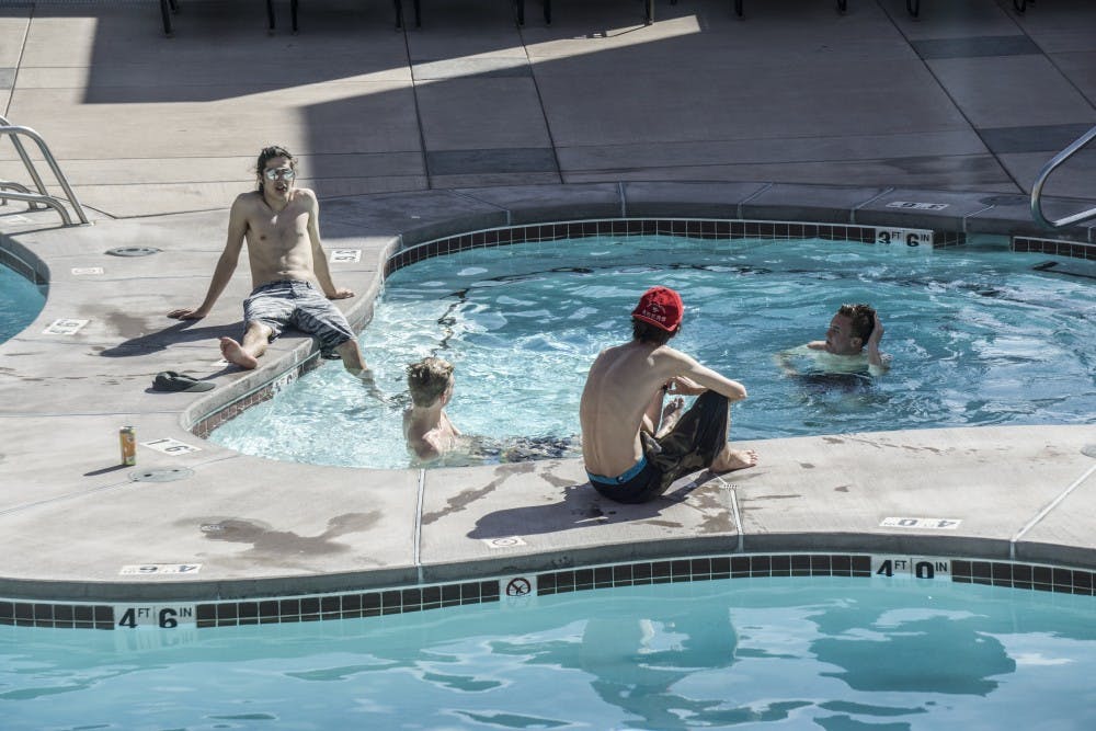 Lobo Village residents relax at the on-site pool on March 31, 2018.