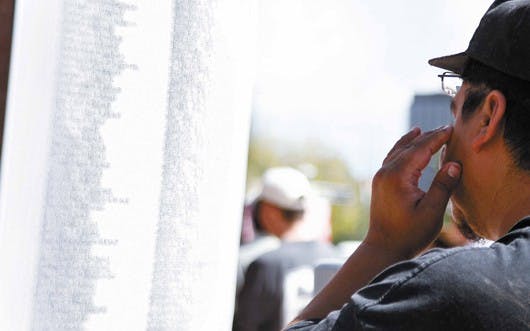 Dominic Trujillo dries his eyes Downtown in Civic Plaza while looking at the list of names of victims who died in the terrorist attacks on Sept. 11, 2001. The event, which marked five years since Sept. 11, was the largest of its kind in New Mexico.