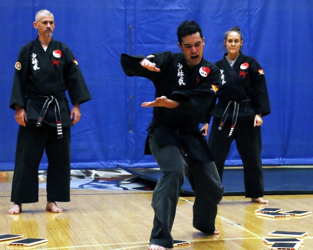 Josh Jacquez (center)&nbsp;prepares himself for a martial art called Shoa-Lin Kung Fu Wednesday night at the 4th annual Martial Arts Expo at Johnson Gym. Sensei Abraham Tames (left) and Sedjenane Chang (right) broke boards upon&nbsp;Jacquez's arms and legs.&nbsp;