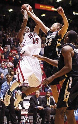 UNM's J.R. Giddens shoots against Colorado's Richard Roby in the first half of Tuesday's game at The Pit. The Lobos won 106-65.  