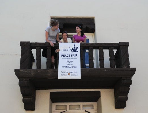 From left: Pavlina Peskova, Camila Mejia and Lisa Galindo help prepare for Wednesday's Peace Fair, which will be in SUB ballrooms A and B. 