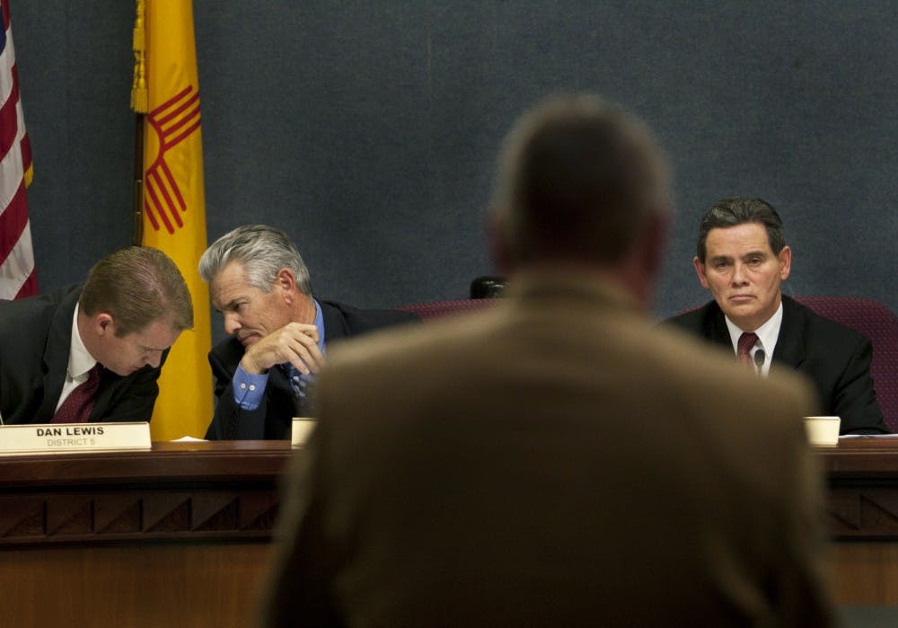 	Dist. 5 Councilor Dan Lewis (left) talks to Brad Winter from Dist. 4 while Tim Cass, the UNM Senior Associate Athletics Director gives his remarks supporting UNM’s waiver to sell alcohol during football and basketball games at Monday’s city council meeting in the Vincent E. Griego chambers. The council denied the request by a 6-3 vote