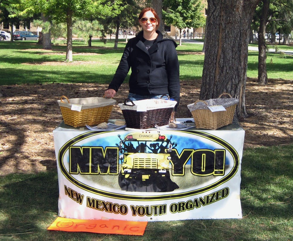 	Cheyenne Beardsley, co-chairwoman of UNM’s chapter of New Mexico Youth Organized, stands behind the group’s fruit stand near the Duck Pond. The stand offers locally grown fruit for $1 or less.