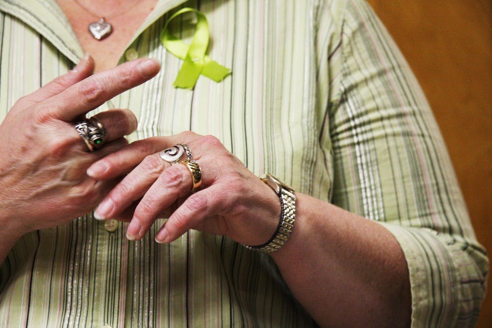 	Ashley’s mom, Christine, plays with the assortment of rings on her fingers. Three of the rings are Ashley’s, and Christine said she’ll never take them off.