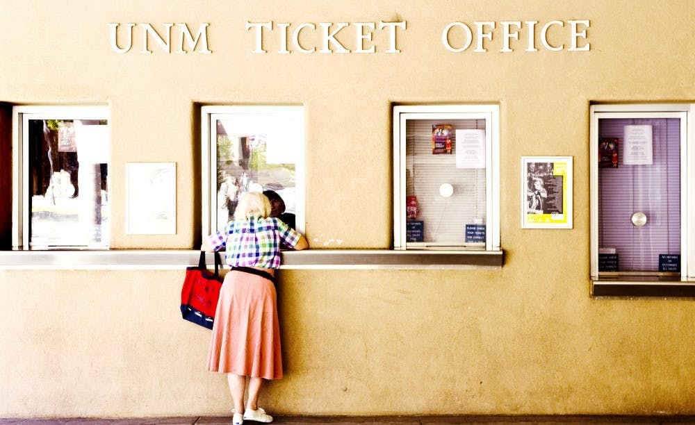 	A woman purchases event tickets at the UNM ticket office Thursday. Ticket sales for home football games has declined by almost 3,000 since this time last year. 