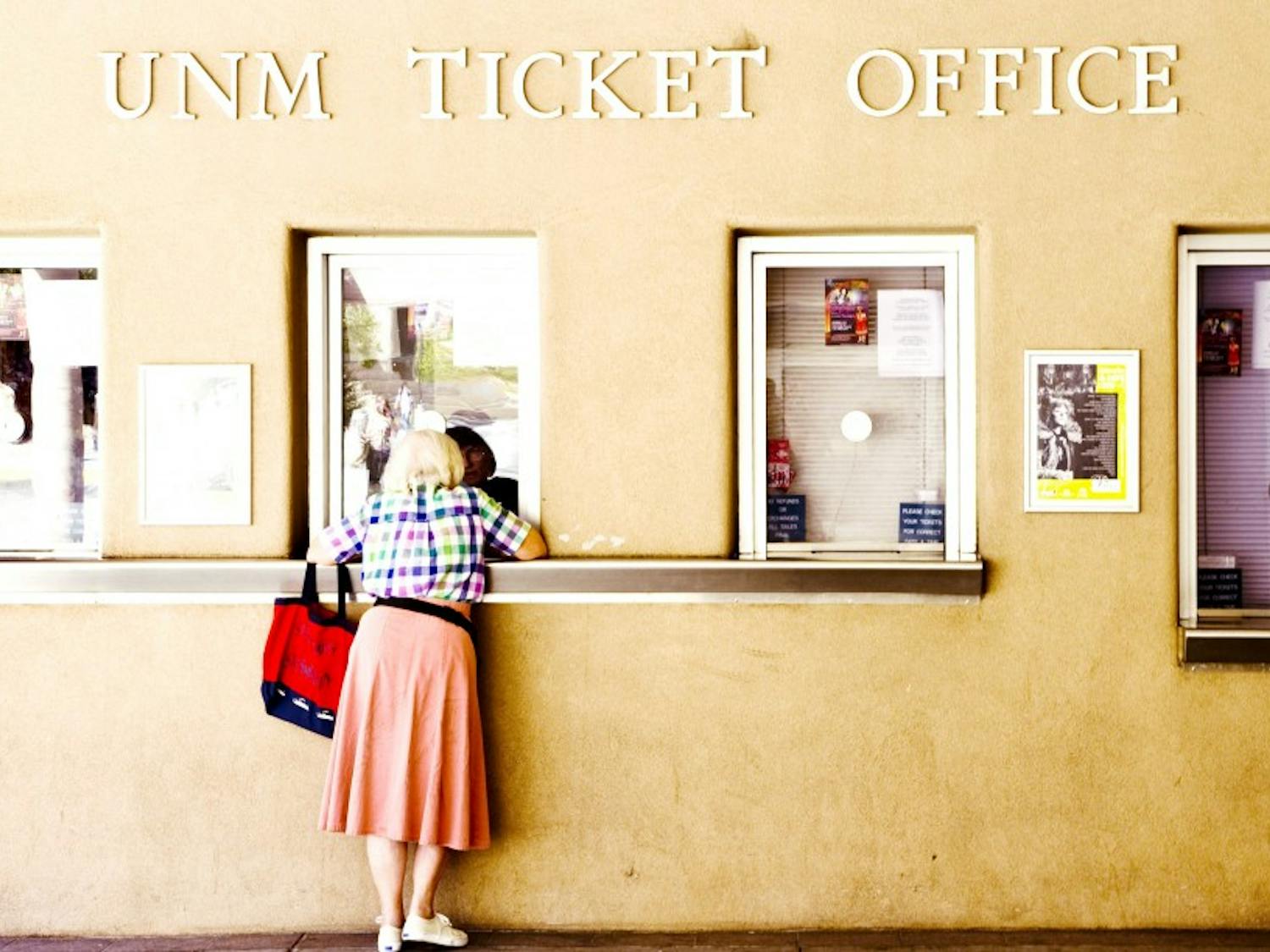 	A woman purchases event tickets at the UNM ticket office Thursday. Ticket sales for home football games has declined by almost 3,000 since this time last year. 