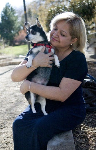 Anne-Elisabeth Rae sits with her dog Scooter at the Duck Pond on Thursday. Rae encountered problems with a professor when she brought the dog to class, though she is licensed to bring him for a disability. Associated Students for Empowerment will host eve