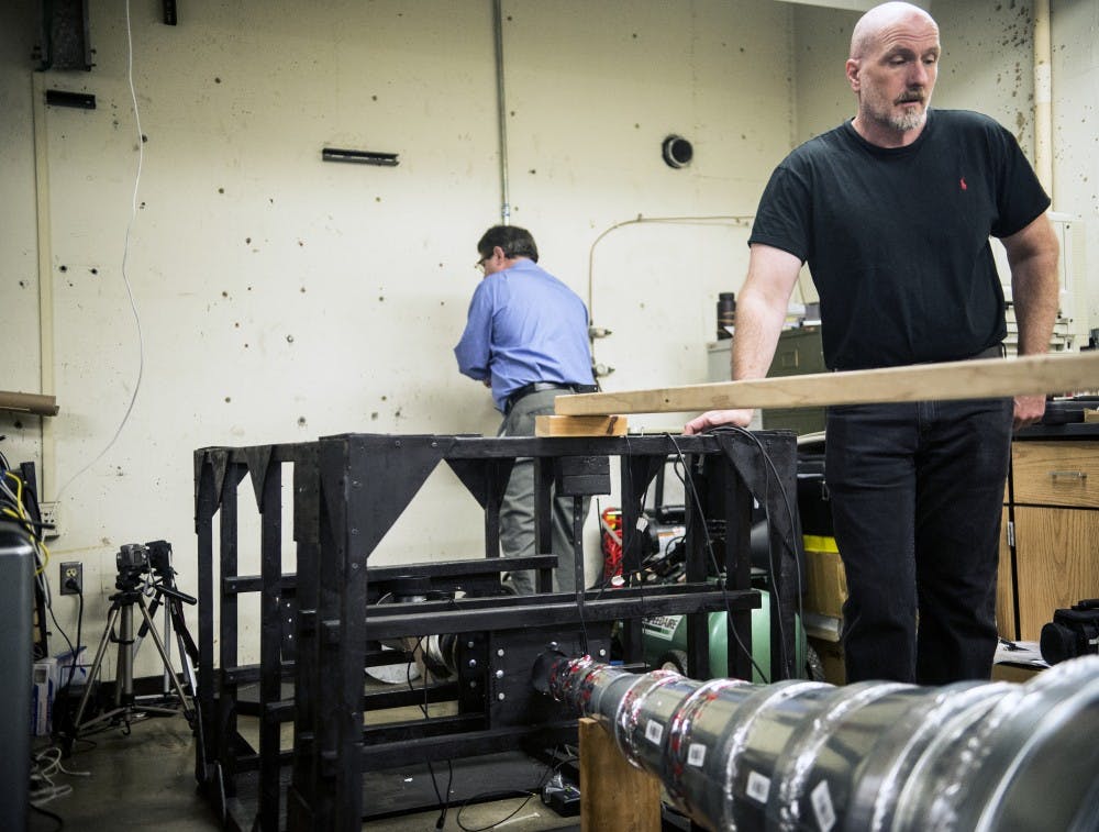 Peter Vorobieff (right) and Craig Davidson set up their hybrid propulsion test rig at the Mechanical Engineering Building Tuesday, Oct. 27, 2015. Vorobieff and Davidson are using a series of magnets that aid the process of charging&nbsp;ions to create an efficient source of propulsion.&nbsp;