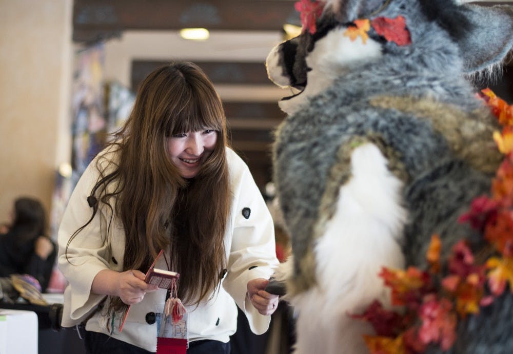 Yukiho Tanaka, left, shakes hands with Danielle Kemper at Sabaku Con Friday. Kemper is a professional cosplayer that suites up a fuzzy during conventions, while Tanaka visited from Japan to attend Sabaku Con, making up a diverse crowd of cosplayers and attendees. 