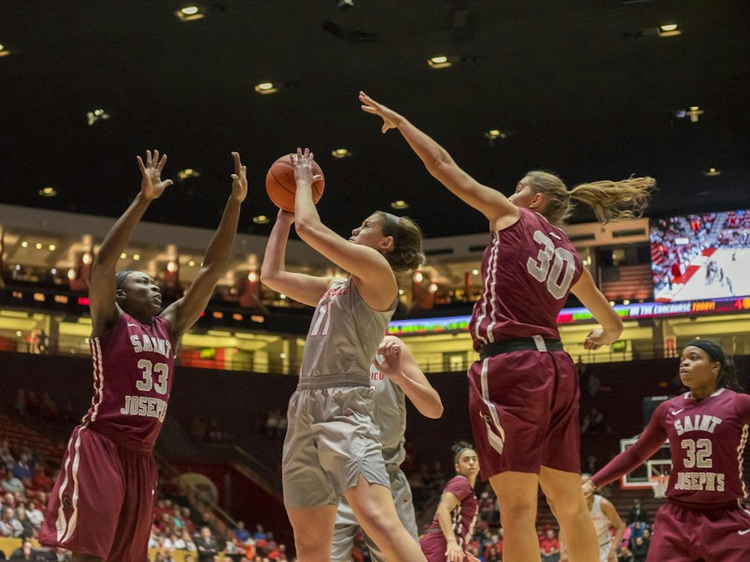 Emily Lines (11) attempts a shot against Joseph's tough defense on Saturday November 26th at WisePies Arena