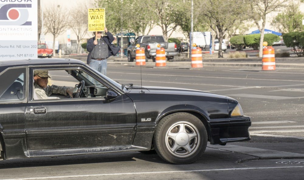 A man n a military uniform watches the Syrian war protest from his car as he drives by on Thursday, April 12, 2018. &nbsp;