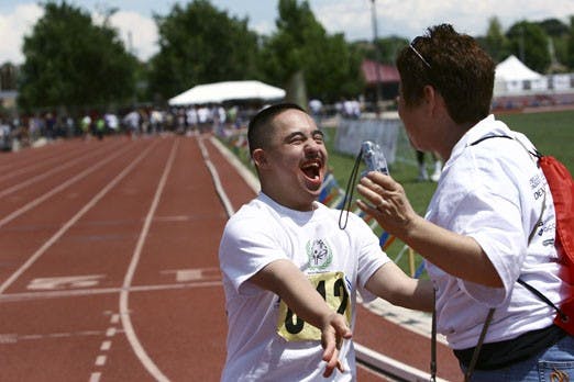 Sergio Renteria greets Luz Mar&iacute;a Mu&ntilde;ez during the Special Olympics at the UNM Track Complex on Saturday. This was the largest state summer games event in the history of Special Olympics New Mexico. 