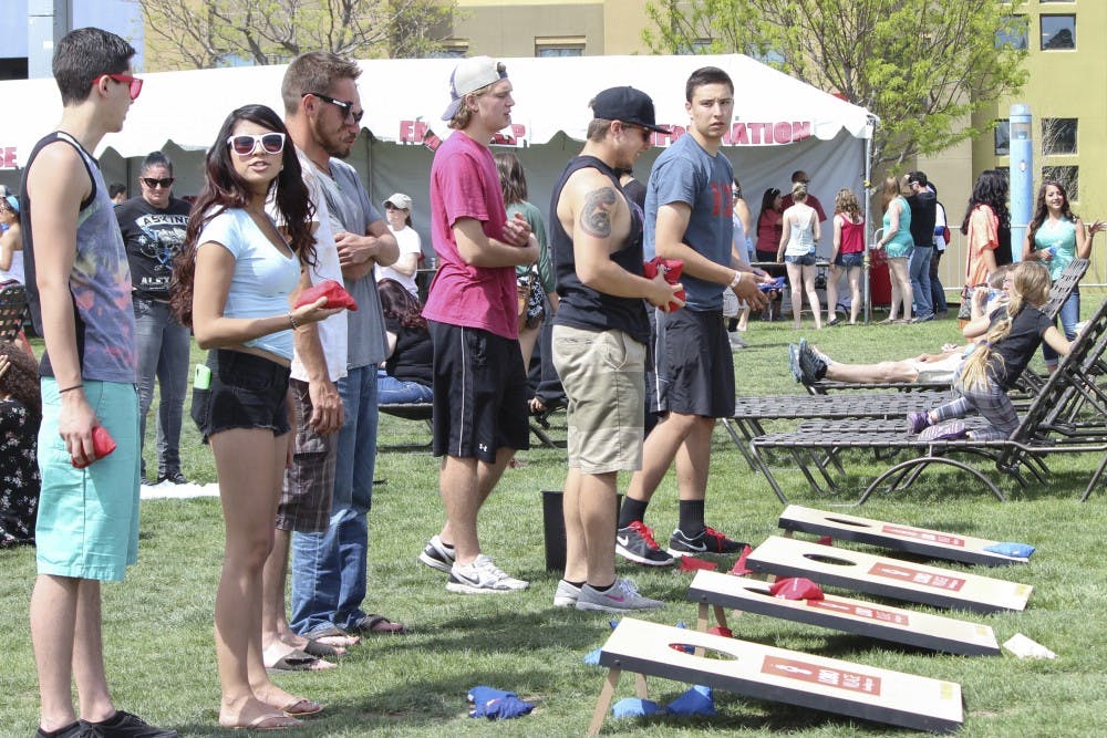 UNM students play bean bag toss on Johnson Field Saturday afternoon during Fiestas. 