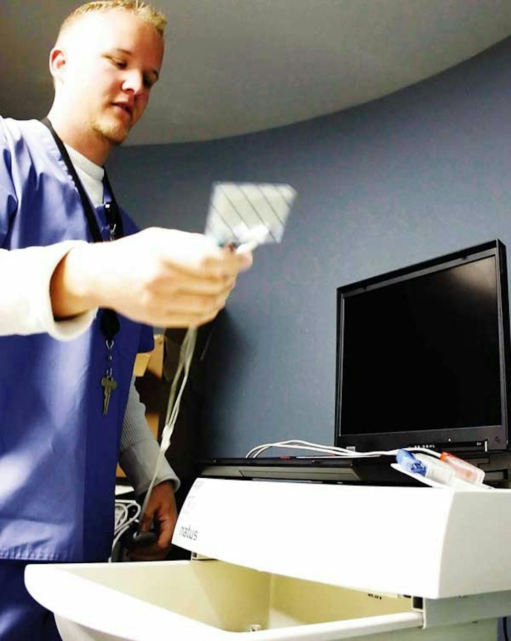 Student Cody Grassham preps a hearing-screening machine Saturday at UNM Hospital. 