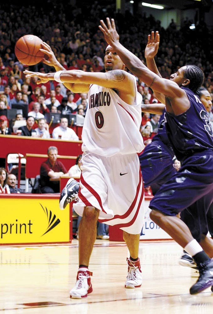 UNM forward Aaron Johnson passes the ball to a teammate while Kansas State's Deilvez Yearby defends during Tuesday's 78-54 win at The Pit.