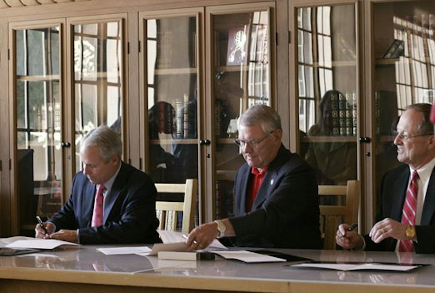 Mayor Martin Chavez, left, UNM President David Schmidly, and Sandia National Laboratories President Tom Hunter sign a Memorandum of Understanding in Zimmerman Library on June 19. The MOU provides for a collaborative agreement between the three parties.