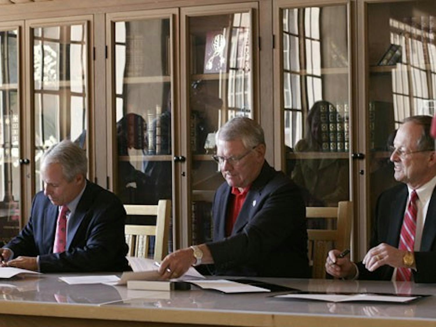 Mayor Martin Chavez, left, UNM President David Schmidly, and Sandia National Laboratories President Tom Hunter sign a Memorandum of Understanding in Zimmerman Library on June 19. The MOU provides for a collaborative agreement between the three parties.