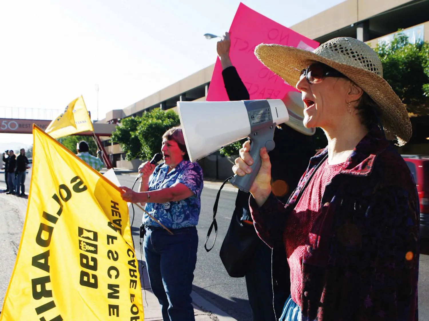UNM Hospital social worker Cynthia Goldblatt yells into a megaphone during a protest at the hospital on June 1. The hospital workers picketed to raise awareness about employee wages.