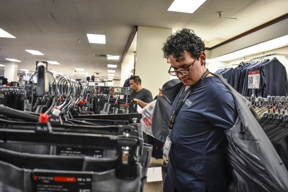 A University of New Mexico Hospital employee shops for a suit during College Suit Up on Sunday, Aug. 26.
