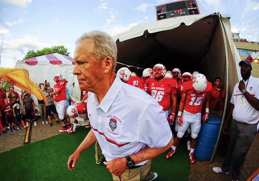 UNM football head coach Bob Davie leads the Lobos out of the tunnel on Sept. 1, 2016 at University Stadium.