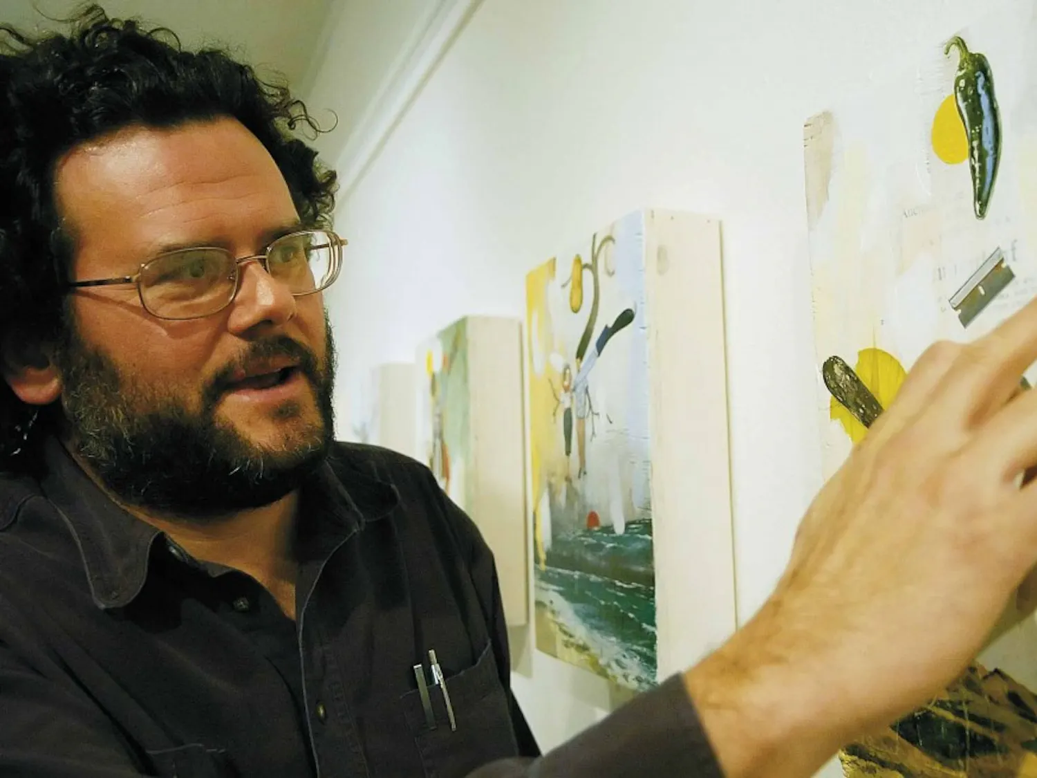 Artist David Nakabayashi points out a grade school award he received that is collaged into his work titled "I'd Rather Be Swimming" on Friday at the Yale Art Center.