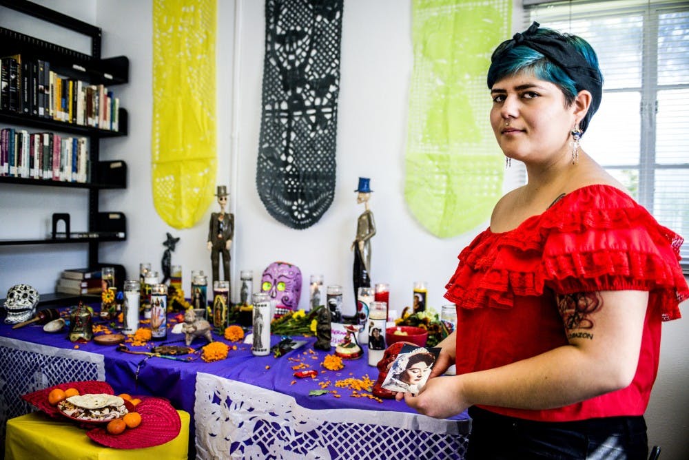 Selina Villa holds a photo of their grandmother to be placed on the Día De Los Muertos altar located in the UNM LGBTQ Resource Center, Nov. 2, 2017. Attendees were invited to place mementos, photos, dulces and traditional offerings on the blessed altar.