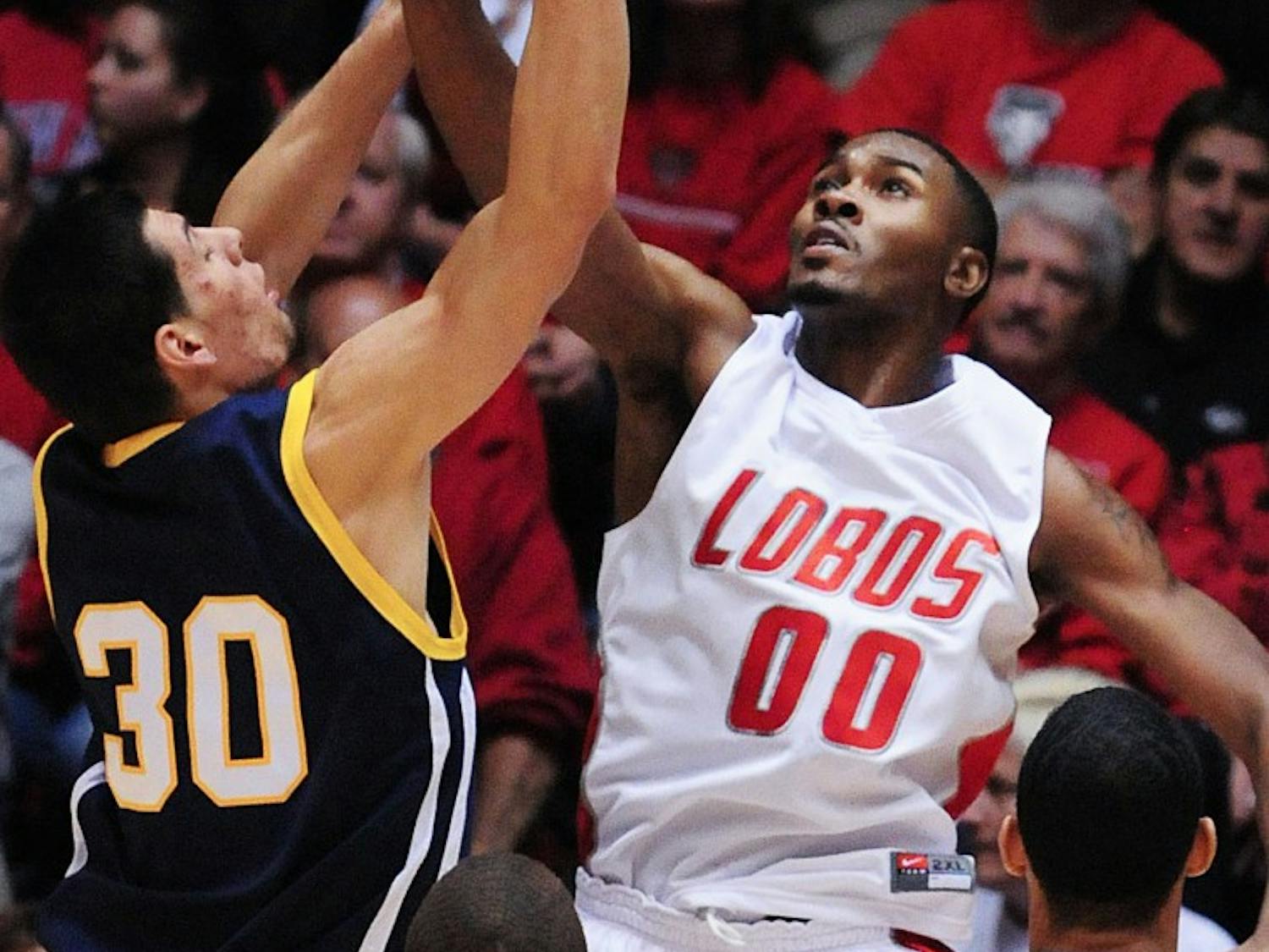 Forward A.J. Hardeman swats a shot by UC-Riverside’s David Chavira during UNM’s opening regular-season game Saturday at The Pit. The Lobos won 67-51 and Hardeman had 14 points in 28 minutes.