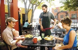 Green Light Bistro server and cook Keith Williams serves Nick and Maggie Middleton and their daughter Marlowe during lunch at the restaurant on Silver Avenue on Monday.