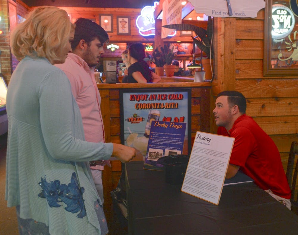 Vice President of UNM Sigma Chi Joe Trujillo talks to Jeff Dan Herrera, middle, and Liz OReilly, left, about their fundraising event that took place at the Texas Roadhouse Tuesday evening. Sigma Chi will hold different events throughout the week.